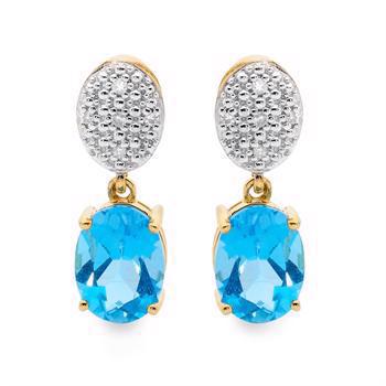 Elegante ørestikker i 9 kt guld med oval lys blå topas og med tre glitrende diamanter i oval over topasen. Måler 18 x 6 mm fra Bee Jewelry