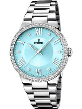 Festina dameur med lyseblå urskive, sølvfarvede romertal, stenbesat bezel og metallisk lænke.