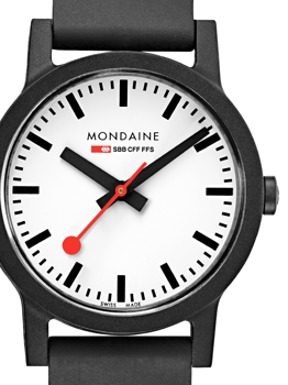Nærbillede af Mondaine ur med hvid skive, sorte markeringer, rød sekundviser, "MONDAINE" tekst.